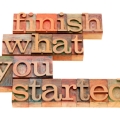 finish what you started - motivational slogan in vintage wood letterpress printing blocks, isolated on white